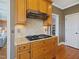 Kitchen cabinet detail with a black cooktop on granite counters and diamond pattern backsplash at 132 Mantle Dr, Clayton, NC 27527