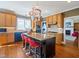A kitchen showcases an island with granite countertops, red stools, light wood cabinetry, and stainless steel appliances at 132 Mantle Dr, Clayton, NC 27527