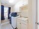 Bright laundry room with a modern washer and dryer, sink, and plenty of cabinet space at 132 Mantle Dr, Clayton, NC 27527