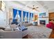 Bright living room with a fireplace, coffered ceilings, and large windows with bright blue curtains at 132 Mantle Dr, Clayton, NC 27527