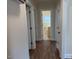 Hallway featuring neutral paint, wood flooring and doors to various rooms in the house at 1421 Deer Crossing Ct, Henderson, NC 27536