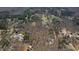 Expansive aerial view showcasing the property's location nestled within a dense and lush wooded area at 1500 Allen Ln, Hillsborough, NC 27278