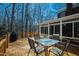 Relaxing back deck with a glass table and four chairs overlooking a peaceful wooded backyard at 1500 Allen Ln, Hillsborough, NC 27278
