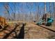 Expansive backyard with mature trees, a wooden playset, and lush greenery at 1500 Allen Ln, Hillsborough, NC 27278