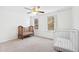 Bright, airy bedroom with ample windows, features a fan and two cribs at 1500 Allen Ln, Hillsborough, NC 27278