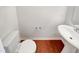 Half bath with toilet and pedestal sink plus decorative brown vinyl flooring at 1501 Copper Cir, Mebane, NC 27302