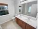 Bright bathroom with a double sink vanity, large mirror, and a window offering natural light at 1501 Copper Cir, Mebane, NC 27302