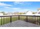Back deck view with a railing overlooking a fenced backyard and neighboring houses at 153 N Farm Dr, Clayton, NC 27527