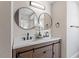 Modern bathroom featuring double sinks, stylish round mirrors, and wooden cabinets with sliding doors at 153 N Farm Dr, Clayton, NC 27527