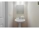 Small bathroom featuring a white pedestal sink with decorative flowers and a mirror at 153 N Farm Dr, Clayton, NC 27527