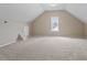 Large bonus room with sloped ceilings, neutral carpet, and a window for natural light at 153 N Farm Dr, Clayton, NC 27527