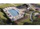 Community pool area featuring lounge chairs, umbrellas, tables, and a recreation area for residents to enjoy at 1560 Bright Coral Trl, Wendell, NC 27591