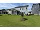 A well maintained, flat backyard with lush lawn, a screened porch, and young trees at 1560 Bright Coral Trl, Wendell, NC 27591