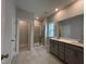 Bright bathroom featuring a gray double sink vanity, a large glass shower and a window at 1560 Bright Coral Trl, Wendell, NC 27591