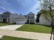 Charming two-story home featuring a well-manicured lawn and a spacious two-car garage at 1560 Bright Coral Trl, Wendell, NC 27591