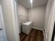 Convenient laundry room with washer, dryer, wire shelving, and hardwood floors at 1560 Bright Coral Trl, Wendell, NC 27591