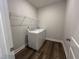 Laundry room with washer, dryer, wire shelving, and hardwood floors at 1560 Bright Coral Trl, Wendell, NC 27591