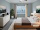 Stylishly staged bedroom featuring neutral tones, ample light, and modern decor at 157 Auburn Village Blvd, Raleigh, NC 27610