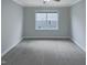 A bright, empty bedroom with soft gray carpet and a large window at 157 Auburn Village Blvd, Raleigh, NC 27610