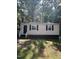Charming one-story home featuring black shutters, a black door, and light siding nestled among mature trees at 158 Torain St, Hillsborough, NC 27278