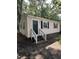 Charming one-story home featuring black shutters, a black door, and light siding nestled among mature trees at 158 Torain St, Hillsborough, NC 27278