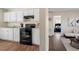 Functional kitchen with white cabinetry, black appliances, and wood-style flooring at 158 Torain St, Hillsborough, NC 27278