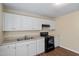Functional kitchen area with white cabinets and essential appliances for meal preparation at 158 Torain St, Hillsborough, NC 27278