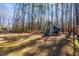 Large backyard with a playground and a wooded area at 1705 Yates Pond Way, Raleigh, NC 27606