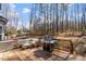 A backyard deck with outdoor furniture and a grill looks out onto a wooded back yard at 1705 Yates Pond Way, Raleigh, NC 27606