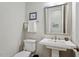 This is a half bathroom with gray walls, toilet, sink, and a mirror at 1705 Yates Pond Way, Raleigh, NC 27606