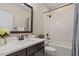 Bathroom with tub and shower, subway tile, dark fixtures, and a dark vanity at 1705 Yates Pond Way, Raleigh, NC 27606