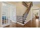 Grand foyer with hardwood floors, staircase, and French doors leading to a sitting room at 1705 Yates Pond Way, Raleigh, NC 27606
