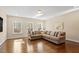 Spacious living room with hardwood floors, large windows, and a comfortable sectional sofa at 1705 Yates Pond Way, Raleigh, NC 27606