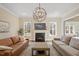 Inviting living room features a cozy fireplace, chandelier, and an open floor plan, perfect for relaxation at 1705 Yates Pond Way, Raleigh, NC 27606