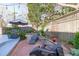 Private backyard with a brick patio, lush landscaping, string lights, and sitting area at 202 Duncan St, Raleigh, NC 27608