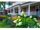 Charming exterior with flowers, manicured landscaping, white pillars and brick facade at 202 Duncan St, Raleigh, NC 27608