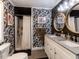 Bathroom with patterned wallpaper, dual sinks, modern fixtures, and a walk-in shower with a white curtain at 205 Old Greensboro Rd, Chapel Hill, NC 27516