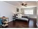 Light-filled bedroom with hardwood floors, a ceiling fan, and a large window overlooking the backyard at 205 Old Greensboro Rd, Chapel Hill, NC 27516