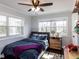 Sunny bedroom with large windows, wood floors, a ceiling fan, and fun decor at 205 Old Greensboro Rd, Chapel Hill, NC 27516