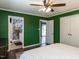 A green-walled bedroom with a ceiling fan has convenient access to the ensuite bathroom and an exterior door at 205 Old Greensboro Rd, Chapel Hill, NC 27516