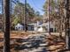 Charming white home featuring a gravel driveway and a well-manicured lawn surrounded by lush trees at 205 Old Greensboro Rd, Chapel Hill, NC 27516