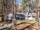 The front exterior of a home with natural landscaping and mature trees offers a serene and private setting at 205 Old Greensboro Rd, Chapel Hill, NC 27516