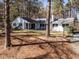 A well-maintained home showcasing mature trees that surrounds the property, offering a sense of privacy and curb appeal at 205 Old Greensboro Rd, Chapel Hill, NC 27516