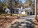 Exterior home showcasing a gravel driveway and well-maintained front lawn surrounded by mature trees at 205 Old Greensboro Rd, Chapel Hill, NC 27516