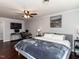 Bright main bedroom featuring a ceiling fan, sleek desk space, and a plush king-sized bed with stylish gray tones at 205 Old Greensboro Rd, Chapel Hill, NC 27516