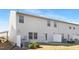 Angled view of the house's backyard, showing the back door, windows, and air conditioning units at 211 Explorer Dr # 263, Morrisville, NC 27560