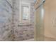 Bathroom showing the shower, glass doors, grab bars and a wallpapered wall with a window at 2122 Woodland Ave, Raleigh, NC 27608