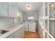 Efficient laundry room with cabinets, countertop, window and modern washer and dryer at 2122 Woodland Ave, Raleigh, NC 27608