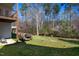 Spacious backyard with a woodpile, picnic table, and mature trees, perfect for outdoor activities at 213 Yellow Poplar Ave, Wake Forest, NC 27587