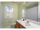 Bathroom with a large mirror, window, toilet, and sink with wood cabinet storage at 213 Yellow Poplar Ave, Wake Forest, NC 27587